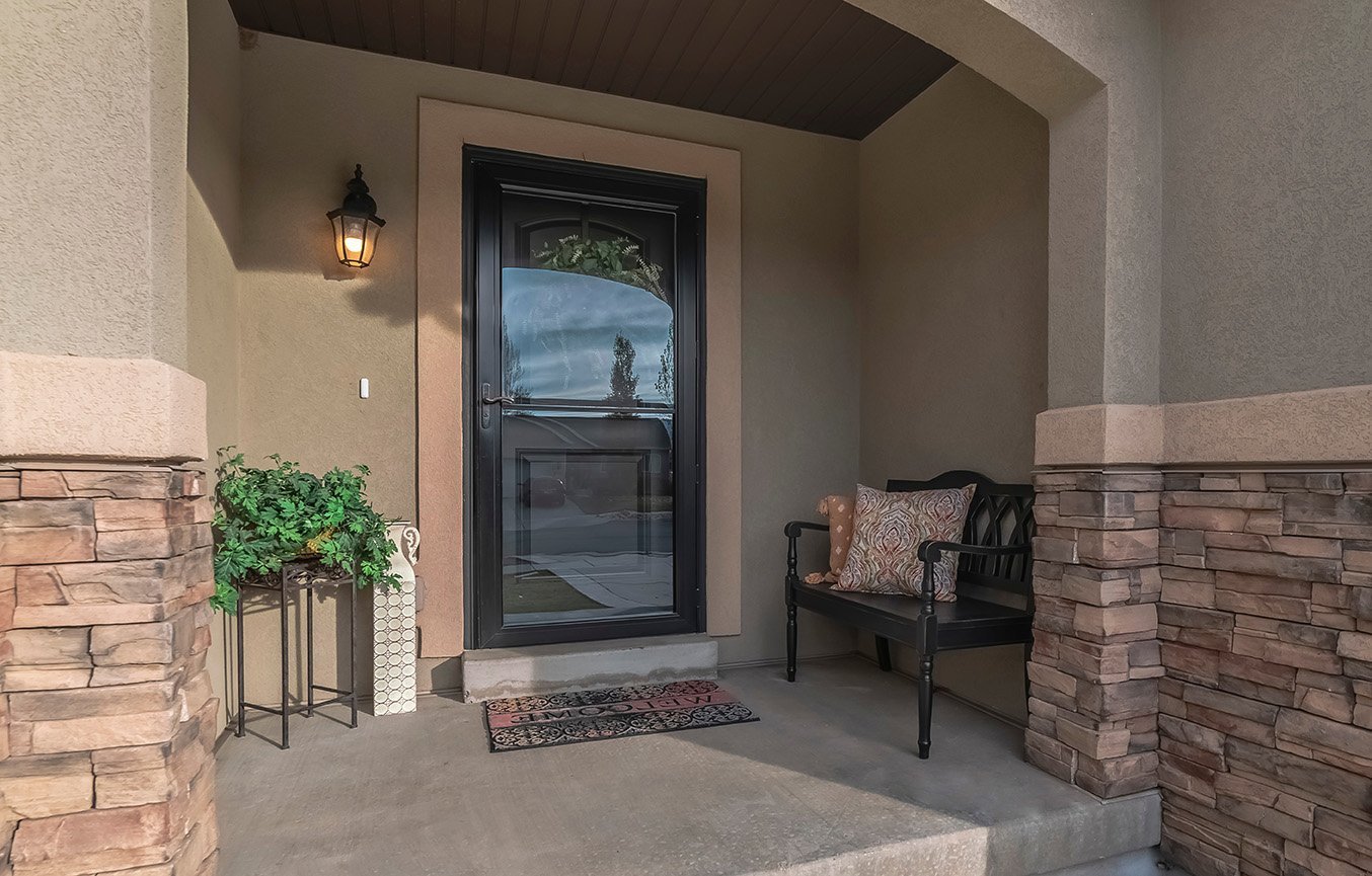 Black full-view storm door with arched glass on stone porch Knoxville